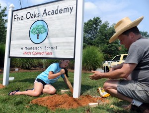 Montessori Student Works On Sign For Independent School